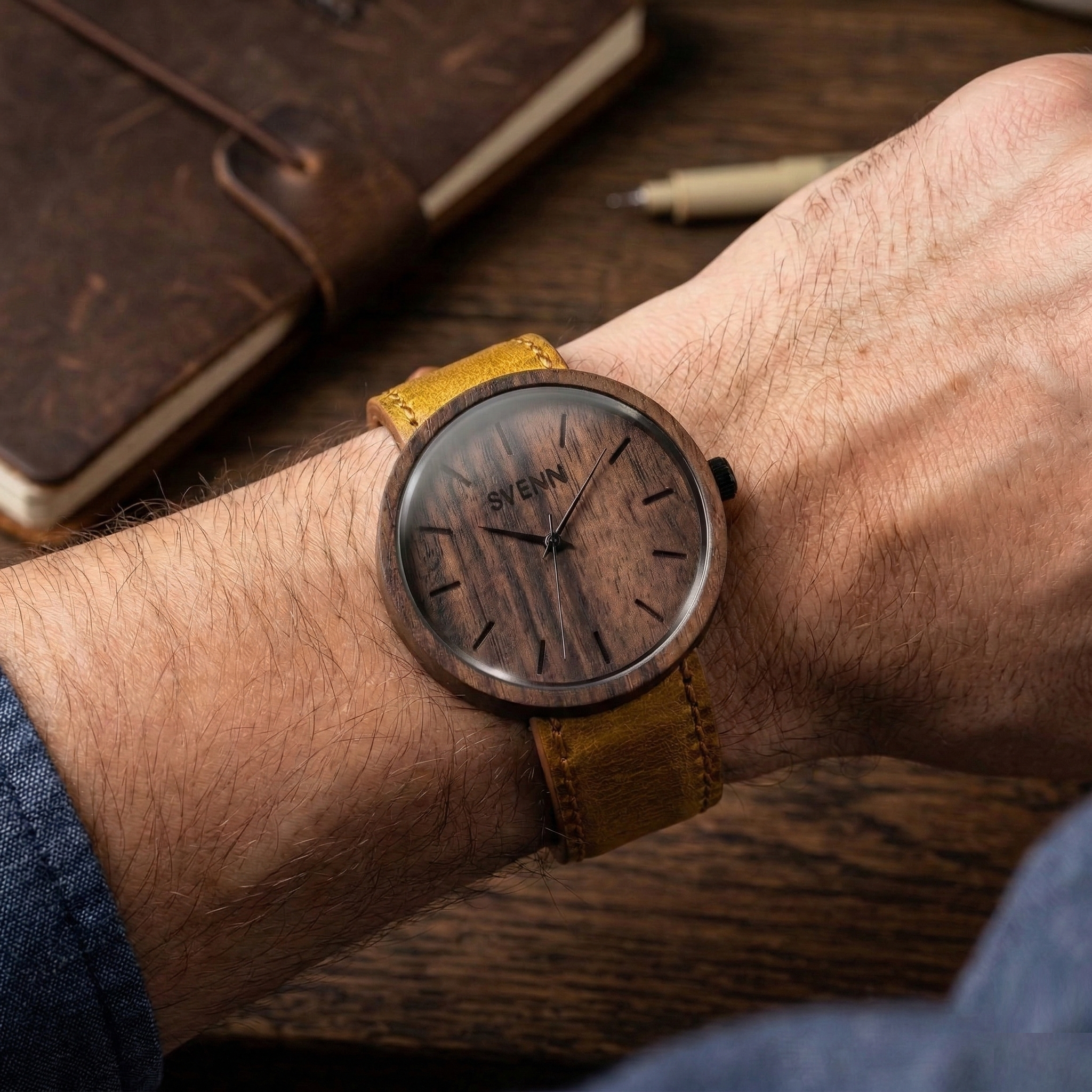 Erkek kolunda şık duran, ceviz ağacının sıcak tonlarını yansıtan el yapımı Svenn ahşap saat tasarımı.